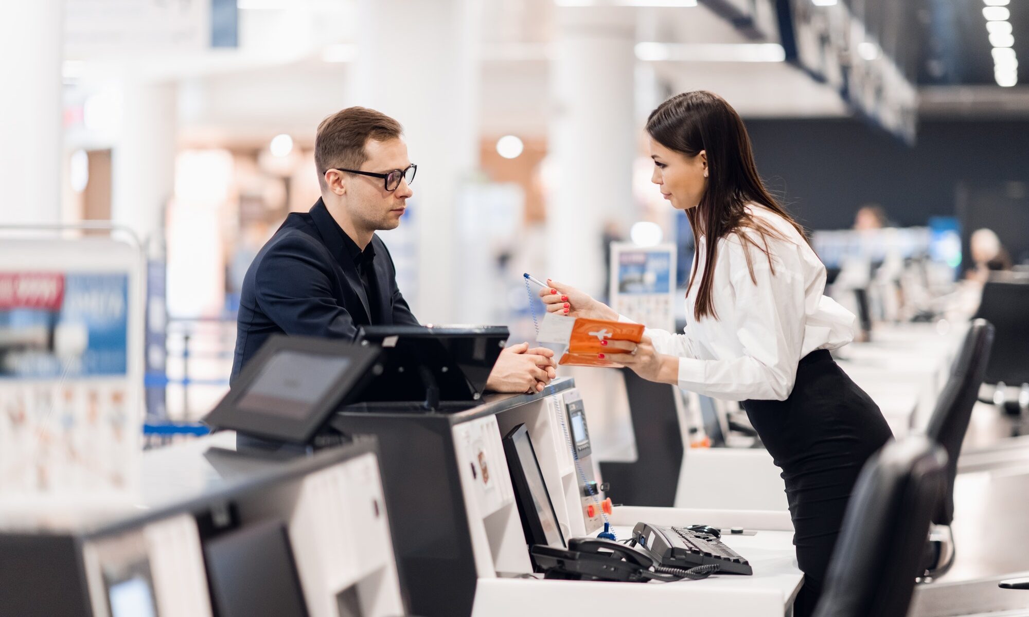 handsome businessman handing over air ticket at airline check in counter