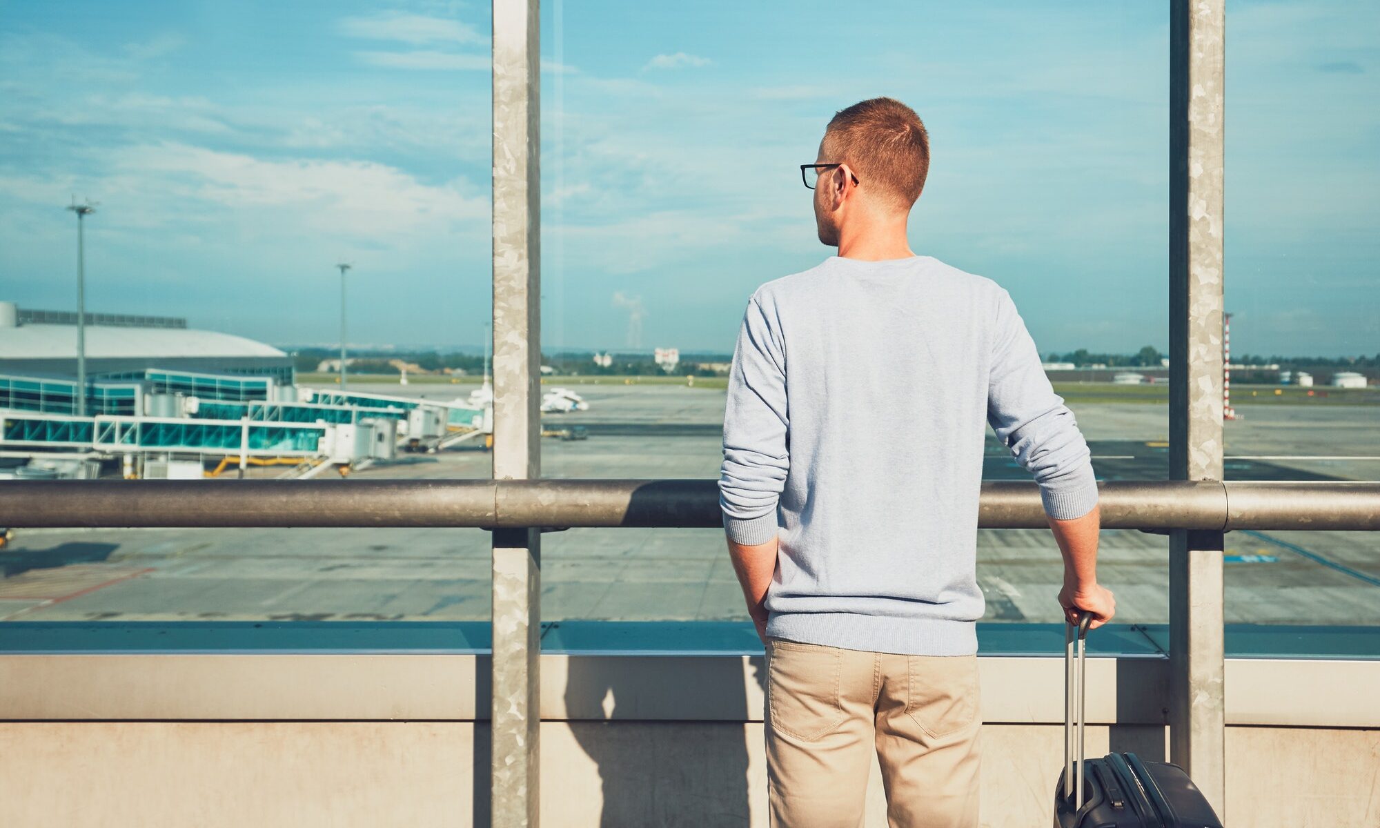 Man traveling by airplane. Young passenger waiting at the airport for a delayed flight.