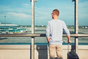 Man traveling by airplane. Young passenger waiting at the airport for a delayed flight.